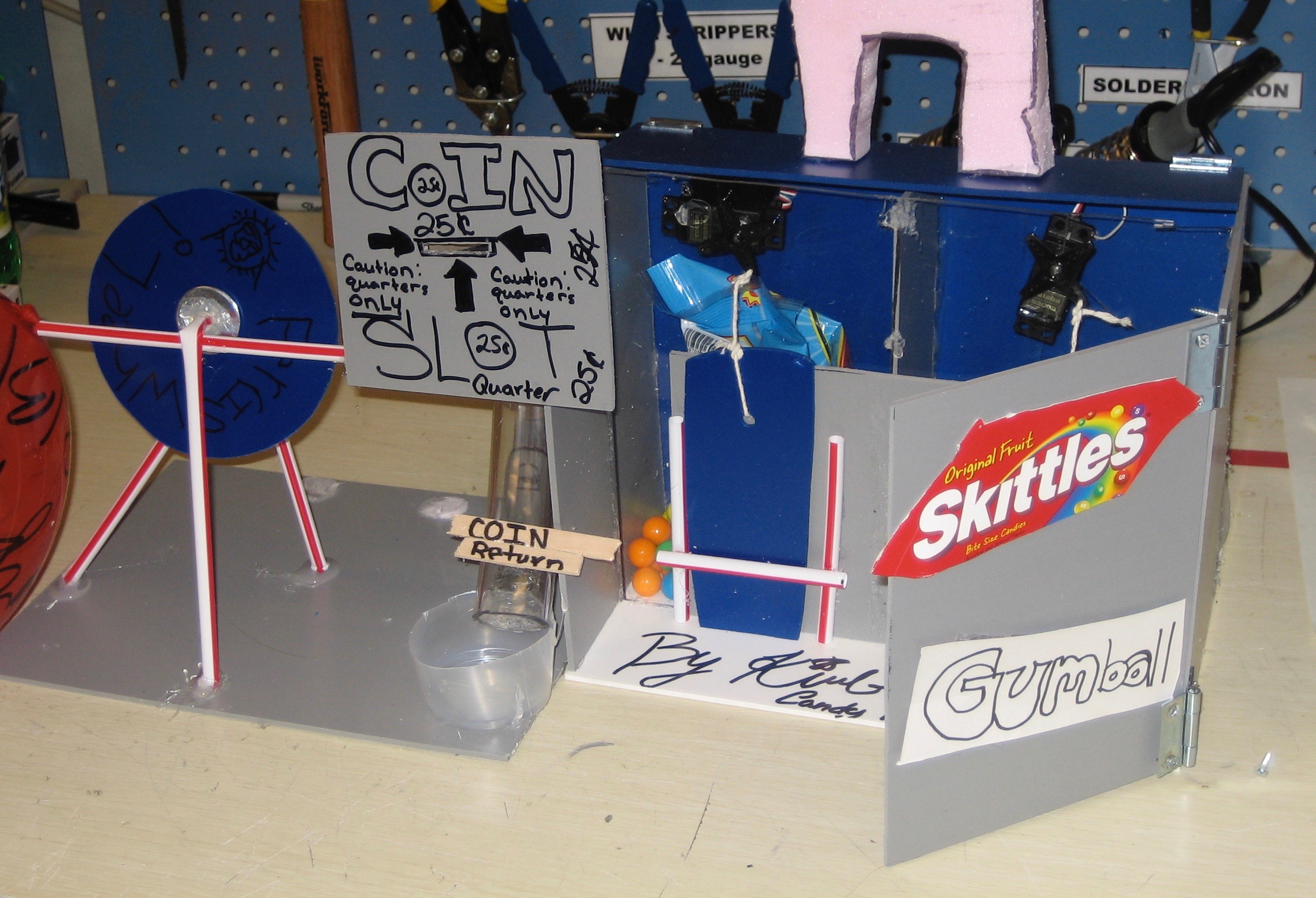 girl shown with candy vernding machine she built